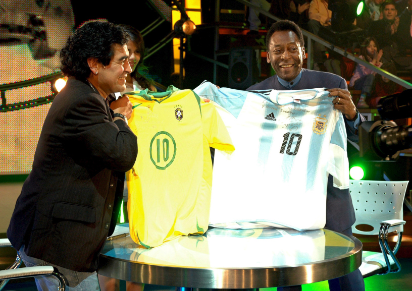 Argentinean former soccer star, Diego Maradona (L), holding a Brazilian national soccer team jersey as his Brazilian counterpart, Pele, displays an Argentinian one